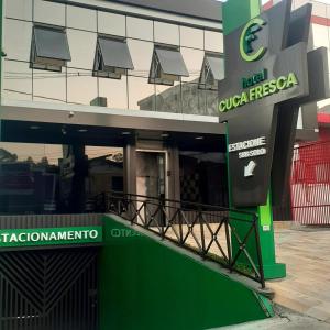 un edificio con una señal verde delante de él en HOTEL CUCA FRESCA - COTIA, en Cotia