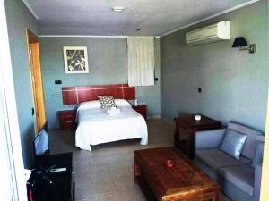 Habitación de hotel con cama y sofá en Hostal Playa Mazagon (El Remo), en Mazagón