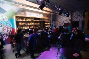 a group of people sitting at a bar in a restaurant at ClinkNOORD Hostel in Amsterdam