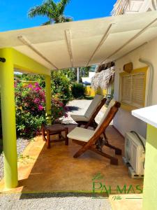 a patio with a chair and a table and an umbrella at Villa Las Palmas in Las Galeras