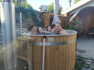 um grupo de pessoas sentadas numa banheira de hidromassagem em Chalet "Het Biggetje" met hottub em Volkel