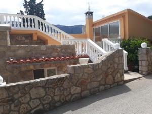 a house with a stone wall and a staircase at Apartments House Marija in Vrbanj