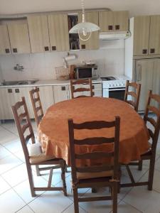 a kitchen with a table and chairs and a kitchen with a stove at Apartments House Marija in Vrbanj