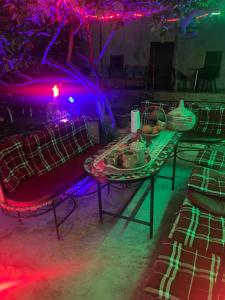 Cette chambre comprend une table et des lumières violettes. dans l'établissement AUBERGE El HAJ BOUAYYADY ZOUAKINE, 