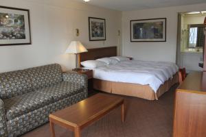 Habitación de hotel con cama y sofá en Knights Inn Indianapolis, en Indianápolis