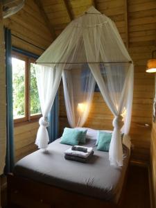 una camera con letto a baldacchino in una cabina di Les Terrasses de Niagara a Sainte-Suzanne
