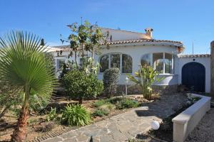 une maison blanche avec un palmier en face dans l'établissement Hana, à Els Poblets