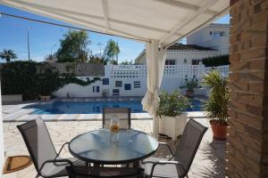 une terrasse avec une table, des chaises et une piscine dans l'établissement Hana, à Els Poblets