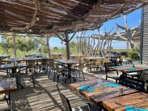 an outdoor dining area with tables and chairs at Camping Les Bois Flottés in Salin-de-Giraud