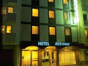 um hotel com uma placa em frente a um edifício em Hotel Montree em Munique