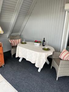 una mesa blanca con 2 sillas y una botella de vino en Ferienwohnung Südel App.2, en Malente