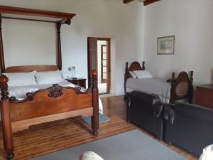 a bedroom with two beds and a couch in it at Mooiplaas Wine Estate in Stellenbosch