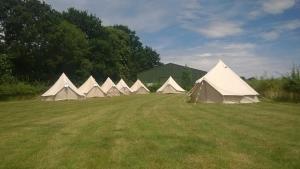 a row of white tents in a field at Holiday Home Virginia Barn in East Harling