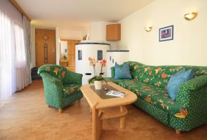 sala de estar con sofá verde y 2 sillas en Sporthotel Schieferle en Innsbruck