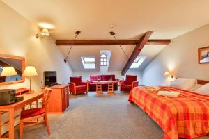 a bedroom with a bed and a desk and chairs at LH Hotel Dvořák Tábor Congress & Wellness in Tábor