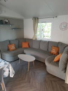 a living room with a couch and a table at Mobilhome La Carabasse Vias Plage in Vias