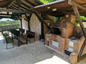 a patio with a brick fireplace and a table and chairs at Eden Maison in Slănic-Moldova