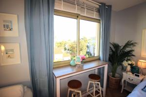 een kamer met een raam met twee krukken voor een tafel bij La Californie Views in Cannes