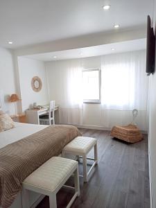 a bedroom with a bed and a desk and a window at SUPERTUBOS HOUSE Peniche in Peniche