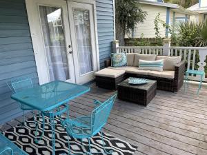 a patio with a couch and a table and chairs at The Painted Lady, a spacious renovated 4BR Victorian in Saint Augustine