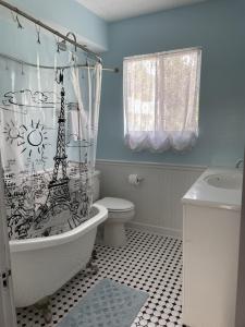 uma casa de banho com uma cortina de chuveiro com a torre Eiffel em The Painted Lady, a spacious renovated 4BR Victorian em Saint Augustine