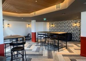 a bar with tables and stools in a room at Résidence Odalys Tourotel in Val Thorens +56 photos
