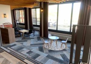 een kamer met een tafel, stoelen en ramen bij Résidence Odalys Tourotel in Val Thorens