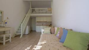ein Wohnzimmer mit einem Sofa und einer Treppe in der Unterkunft Ageri Studios in Astypalea-Stadt