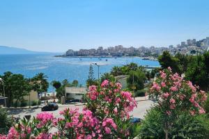 vistas a la ciudad y al océano con flores rosas en J&M Luxury Apartments Saranda 2, en Sarandë