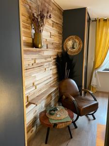 uma parede de madeira num quarto com uma cadeira e uma mesa em La Cense au bois em Saint-Amand-les-Eaux