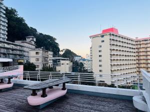 Esperanza Resort Atami-エスペランサリゾート熱海 في أتامي: مقعد على سطح مبنى