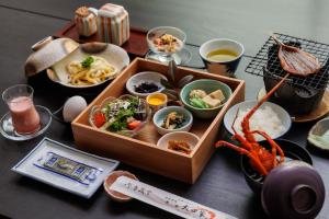 - une table avec un plateau de nourriture et des bols de nourriture dans l'établissement Ise-Shima Ohtaya Healing Stay, à Toba