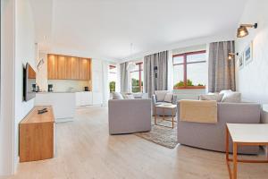 a living room with a couch and a table at Apartamenty Sun & Snow Neptun Park in Gdańsk