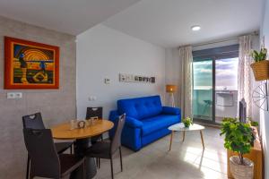 - un salon avec un canapé bleu et une table dans l'établissement POSEIDON Beach Apartment & parking by Cadiz4Rentals, à Cadix