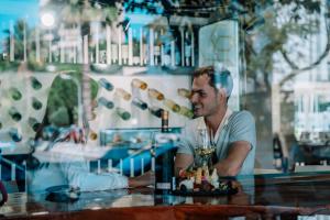 un homme assis à une table avec un verre de vin dans l'établissement Essence Hotel Boutique by Don Paquito, à Torremolinos