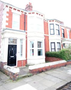 una casa blanca con una puerta negra en una calle en Heaton - Great Customer Feedback - 5 Large Bedrooms - Period Property - Refurbished Throughout, en Newcastle