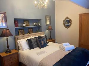 a bedroom with a bed with pillows and a mirror at Broadlands - Adults only in Bourton on the Water