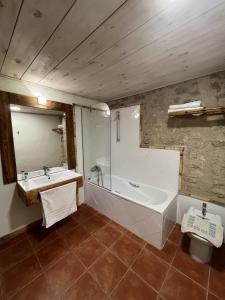 La salle de bains est pourvue d'une baignoire, d'un lavabo et d'un miroir. dans l'établissement El Manzano, à Torre del Compte