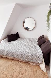 Schlafzimmer mit einem Bett und einem runden Spiegel in der Unterkunft Salty - Vakantiehuisje op de grens van Bredene-De Haan in Bredene