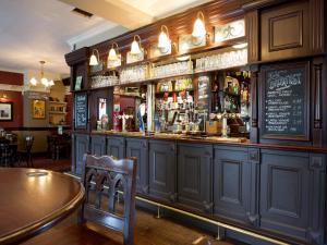 a bar in a pub with a man standing behind the bar at The Beverley by Innkeeper's Collection in Cardiff +13 photos