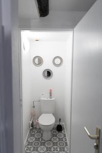 a bathroom with a toilet with two circles on the wall at Le Château Taison au coeur du centre ville in Metz