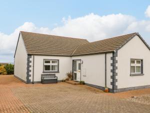 a white house with a brick driveway at Strandview in Coleraine