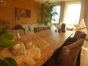 comedor con mesa de madera y sillas en De Zevende Zon en Poperinge