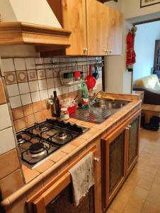 a kitchen with a stove and a sink at Il rifugio del Bracconiere in Roccaraso