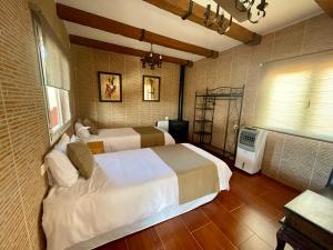 Habitación de hotel con 2 camas y ventana en Villa Aguacate, en Teror