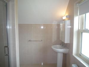 ein Bad mit einem WC, einem Waschbecken und einem Fenster in der Unterkunft Derryleigh House 