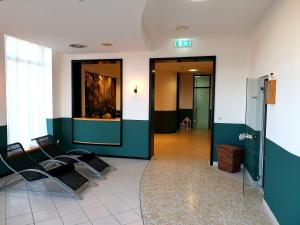 une salle d'attente avec des chaises noires dans un bâtiment dans l'établissement Hotel Löwenstein, à Gerolstein