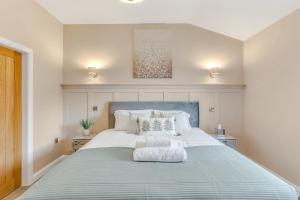 a large bed with a blue headboard in a bedroom at Silver Stag Properties, Luxury Cabin w SK Bed 