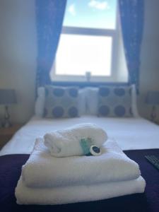 a pile of towels sitting on top of a bed at The Crossroads Inn in Halifax