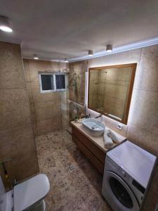 ein Badezimmer mit einer Dusche, einem Waschbecken und einer Waschmaschine in der Unterkunft Mini City Getaway in Rhodos (Stadt)
